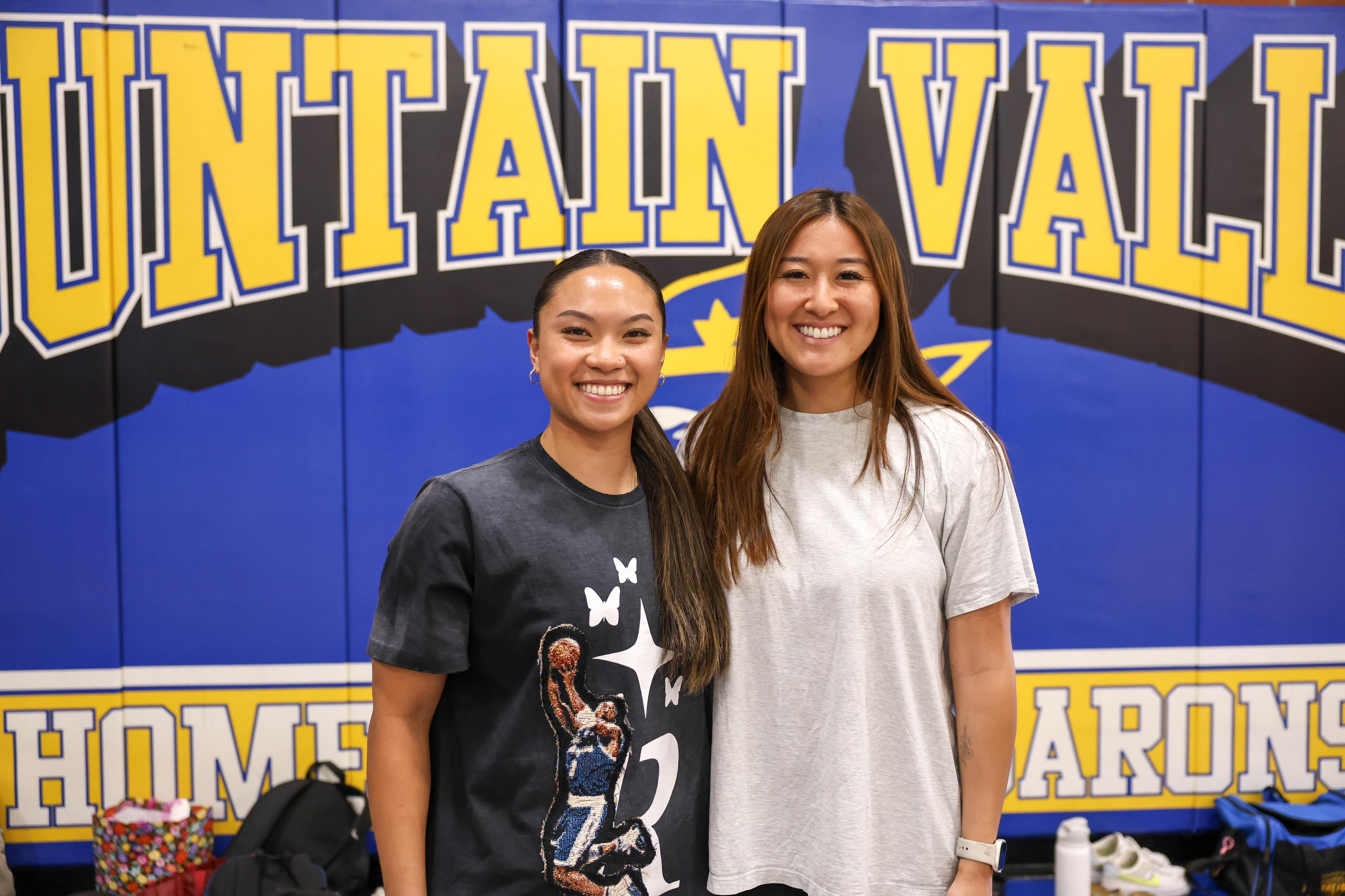 Izabella Om (left) and Camryn Hamaguchi (right) smile in front of FVHS sign